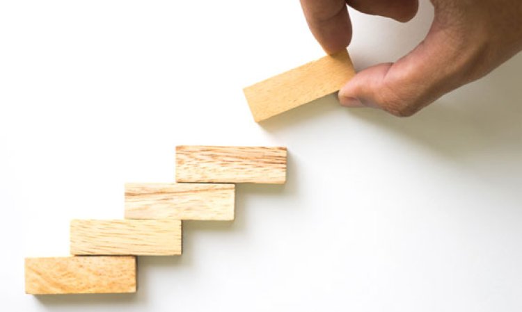 Hand aranging wood block stacking as step stair - By T.Dallas, Shutterstock