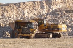 A Caterpillar dump truck being filled with limestone in the plant's quarry, by a Caterpillar tracked back-hoe excavator.